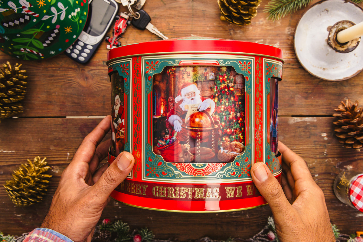 Christmas musical tin held in hands on a festive table